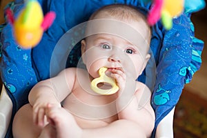 Funny chubby baby with teether in mouth