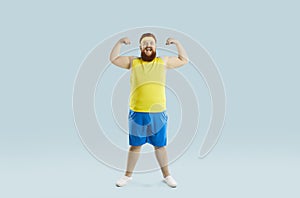 Funny chubby man smiling and flexing his arms during a fitness workout at the gym