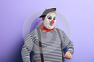 Funny clown with black hat, red nose showing tongue