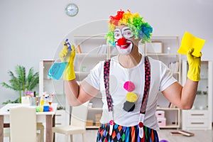 The funny clown doing cleaning at home