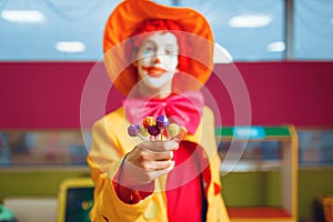 Funny clown with lollipops in children`s area