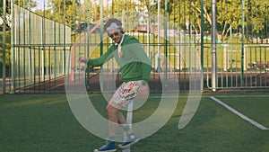 Funny clown man jumping on the tennis court