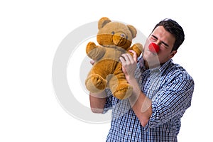 Funny clown man with a soft teddy bear toy isolated on white bac