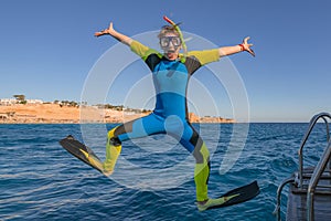 Funny comical snorkeling diver with flippers jump in sea water