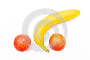 Funny concept of fruit, banana and two red oranges isolated on white background