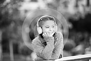 Funny cool stylish girl is listening to music and thinking about positiveness. Girl standing on the bridge with