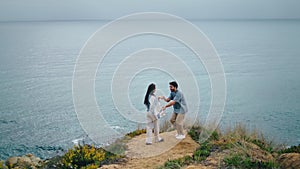 Funny couple dancing sea coast hill cloudy evening. Pair hugging on ocean shore.