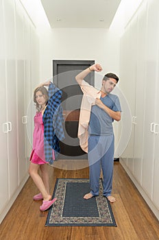 Funny couple getting dressed in pijamas