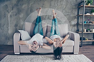 Funny couple with glasses gesturing is lying upside-down on the