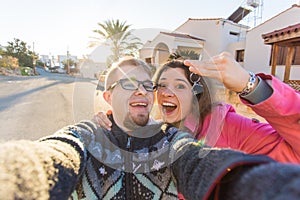 Funny couple With Keys Standing Outside New Home. Real estate, owner and people concept