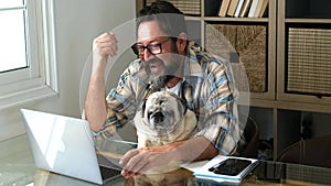 Funny couple man and dog work together at home with laptop online job computer in friendship and happiness - concept of smart work