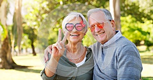 Funny couple, peace sign and portrait outdoor at a park with love, care and hand emoji. A happy senior man and woman