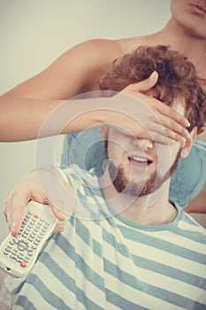 Funny couple on sofa with TV remote