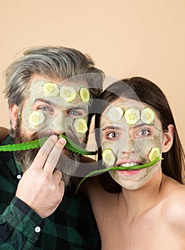 Funny couple spa mask, aloe vera and cucumber on face. Mud facial mask, face clay mask spa. Man and woman with cosmetic