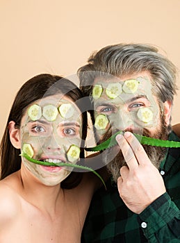 Funny couple spa mask, aloe vera and cucumber on face. Mud facial mask, face clay mask spa. Man and woman with cosmetic