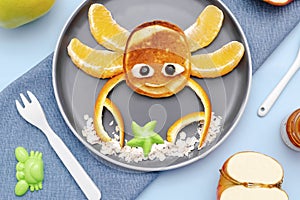 Funny crab face shape snack from pancake, orange,apples,honey on plate. Cute kids childrens baby's sweet dessert, healthy