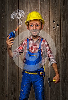 Funny Craftsman with Hammer, cordless screwdriver and helmet