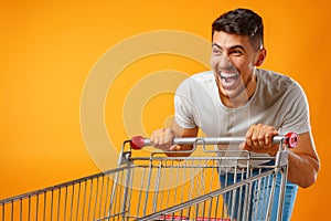 Funny crazy man rushing with shopping trolley to sale