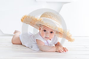 Funny cute child girl 3-4 year old holding straw hat wearing white top and denim shorts posing in park over nature background.