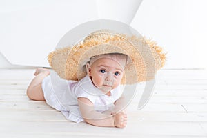 Funny cute child girl 3-4 year old holding straw hat wearing white top and denim shorts posing in park over nature background.