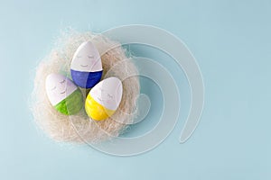 Funny cute eggs in the nest jon blue pastel background, trendy unplug relaxation concept