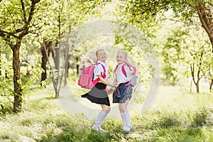 Funny cute girls in school uniform and with backpacks