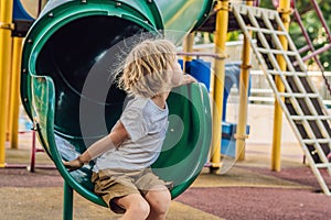 Funny cute happy baby playing on the playground. The emotion of happiness, fun, joy