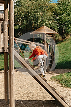 Funny cute happy baby playing on the playground. The emotion of happiness, fun, joy. Smile of a child. boy playing on