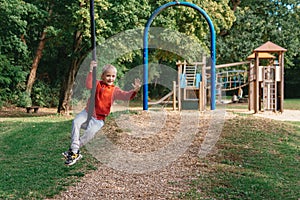 Funny cute happy baby playing on the playground. The emotion of happiness, fun, joy. Smile of a child. boy playing on