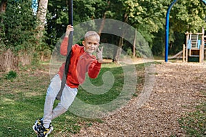 Funny cute happy baby playing on the playground. The emotion of happiness, fun, joy. Smile of a child. boy playing on