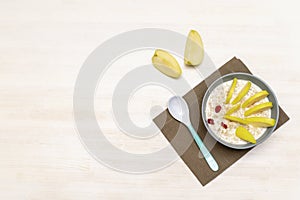 Funny cute kids childrens babys breakfast lunch oatmeal porridge in bowl look like hedgehog decoration with apple, dried cherry