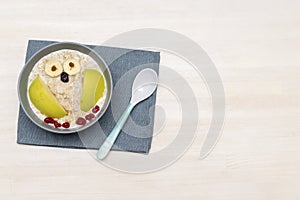 Funny cute kids childrens babys breakfast lunch oatmeal porridge in bowl look like owl decoration with apple, banana