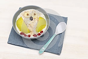 Funny cute kids childrens babys breakfast lunch oatmeal porridge in bowl look like owl decoration with apple, banana, dried berry