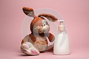 Funny and cute rabbit slob dirty looks at a bottle of soap shampoo or cream soap the importance of hygiene and hand photo
