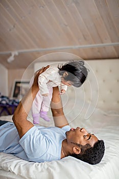 Funny daddy having a fun with his little adorable daughter