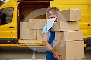 Funny deliveryman carrying pile of cardboard boxes providing professional service