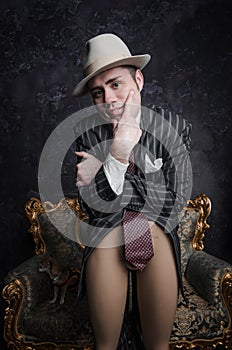 Funny detective in big hat leaned his elbows on bottom bared part of dummy. He looks stright into camera. Studio shot