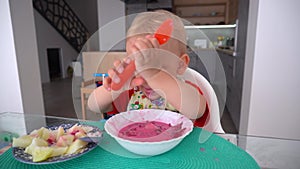 Funny dirty face child. Baby boy eat beetroot soup. Gimbal movement forward
