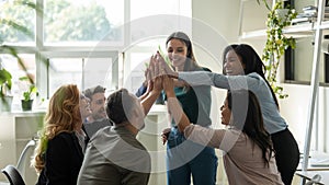 Funny diverse workers with happy female leader giving high five.