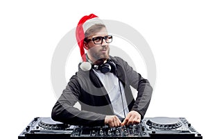 Funny dj guy in Santa's hat, glasses plays music on a turntable while isolated on white background