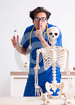 Funny doctor with skeleton in hospital