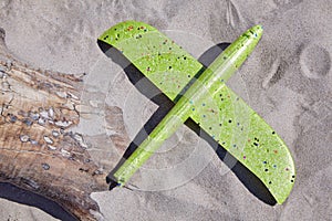 A funny downed green drone lies on the sand