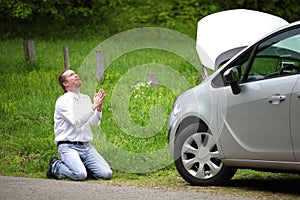 Funny driver praying a broken car