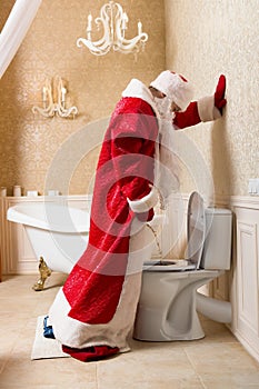 Funny drunk Santa Claus peeing in the toilet