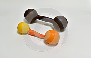 Funny dumbbell made of carrot orange and lemon