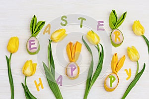 Funny Easter concept. Multicolor letters Happy Easter and wooden eggs with fabric ears as fun bunny