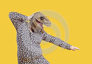 Funny eccentric fat man dressed in leopard print pajamas dancing with dinosaur mask on his head.