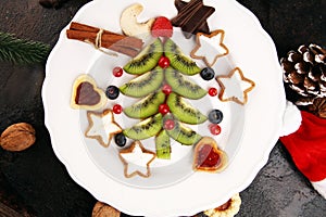 Funny edible Christmas tree, Christmas breakfast idea for kids. Beautiful Christmas and New Year food background with fruits