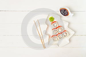 Funny edible Christmas tree made from sushi, creative idea for japanese restaurant on white background. New Year food background