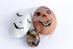 Funny eggs imitating a smiling mixed family with versicolored ba